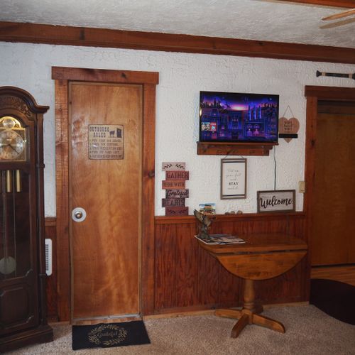 Living room:  includes a sofa, comfy chairs, live-streaming television, and entrance out to the deck.