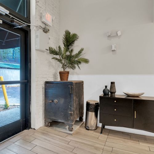 Stylish entryway w/ a dark wood cabinet, potted plant & curated décor.