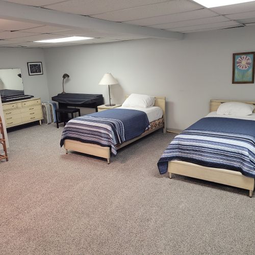 Lower level:  the lower level of the home has 2 single beds, a dresser, a sofa, half-bath, and a large laundry room.