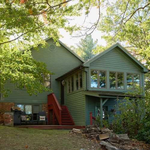The patio complete with grill, down the steps from the all season room with lake views on every side.