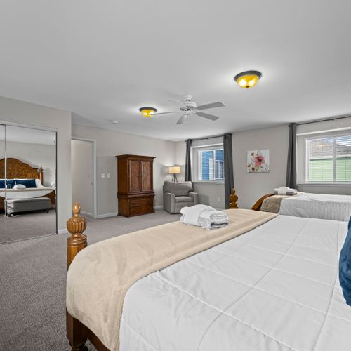 Spacious bedroom with a king and queen bed, ideal for families or groups