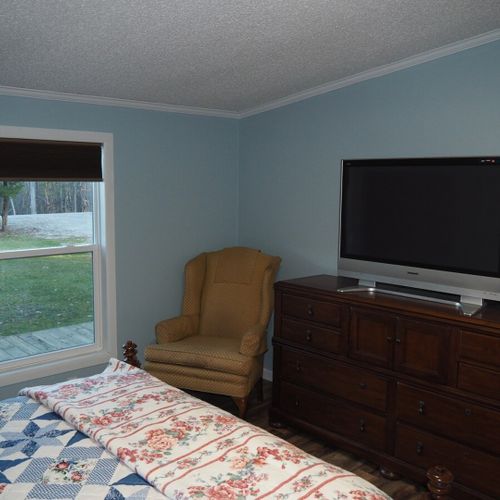 Bedroom #1 (master bedroom):  another angle showing the bedroom window (that faces the front yard), the chair, one of the dressers, and the television that has cable television.