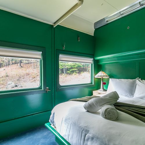 The Adirondack Suite equipped with a closet, bedside table, robes and slippers.