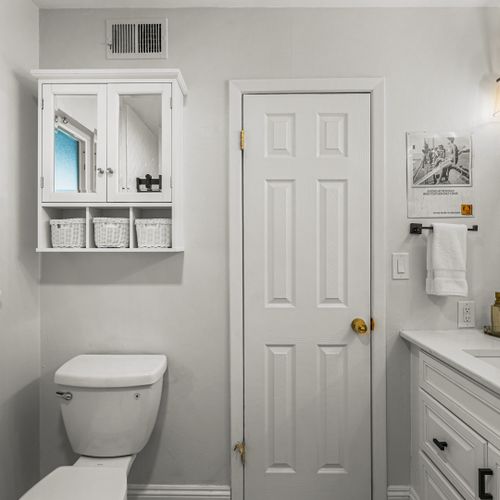 The vanity’s standout mirror brings a bit of modern flair to the bathroom’s simple, clean design.