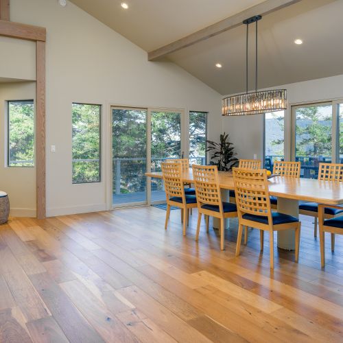 Large windows bring the outdoors inside. Sliding doors open to a large outdoor dining area.