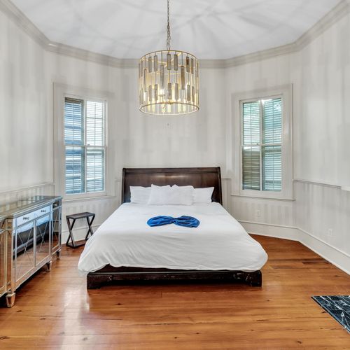 Bright bedroom with cozy charm and a luxurious chandelier.