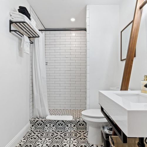 Bright bathroom w/ a soaking tub & natural light filtering through a shaded window.