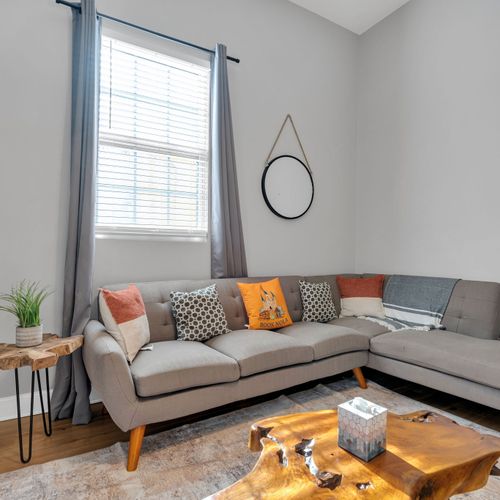 Bright living room w/ a sectional sofa & warm accents — a welcoming space to relax together.