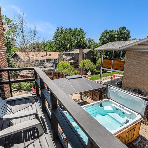 The balcony overlooks an expansive spa pool, resembling an oversized hot tub, creating a luxurious and relaxing retreat right outside the master suite.