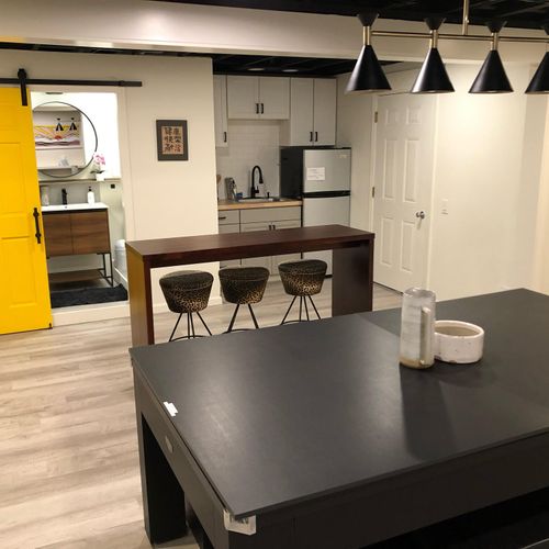 Open concept downstairs with mini kitchen, bathroom, and pool/ping pong table.
