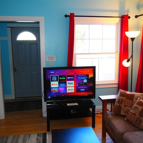Living room:  comfy and cozy living room with sofa, comfy chair, futon, 2 coffee tables, and a large live streaming television that uses the cottage's high-speed cable wi-fi.