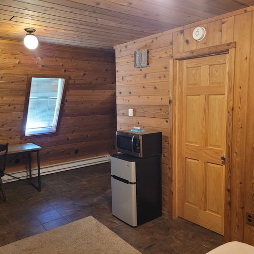 Bedroom #1 (main floor):  features a queen-size bed, private en suite bathroom, desk, dresser, mini-fridge, microwave, portable a/c unit, and its own private entrance.