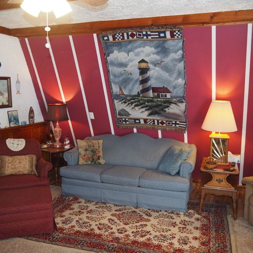 Living room:  includes a sofa, comfy chairs, live-streaming television, and entrance out to the deck.