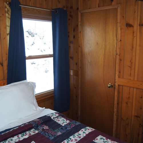 Bedroom #2 (main floor):  features a queen-size bed, nightstand with a lamp, a dresser, and a closet.