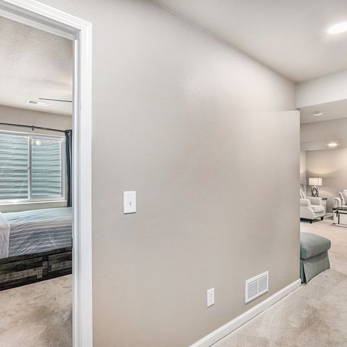 Warm recessed lighting adds a cozy glow to the plush, carpeted floor.