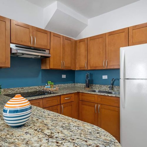 Step into a kitchen space where functionality meets style, equipped with modern appliances and surrounded by warm wooden cabinetry.