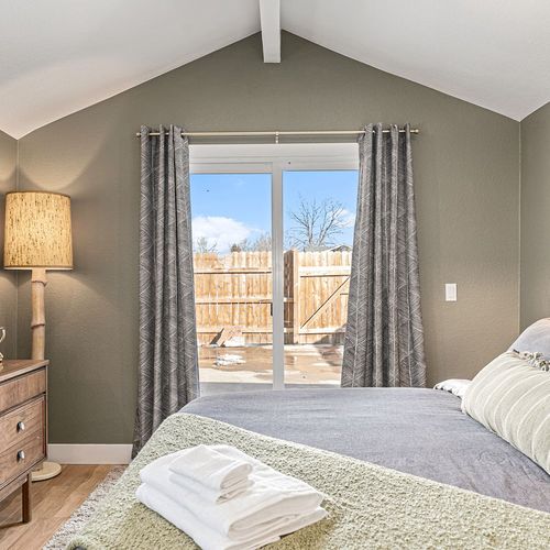 - wake up to sunshine and step outside through sliding doors to a private fenced yard
- vaulted ceilings and soft textures create a peaceful start and end to your day
- bedside lamps and neutral accents add charm to this restful space