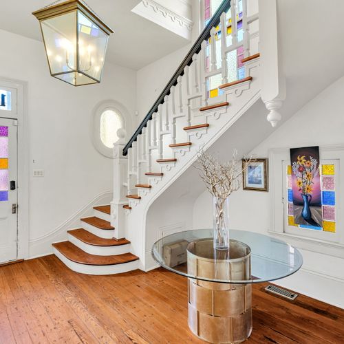 Bright stained glass accents a grand historic staircase.