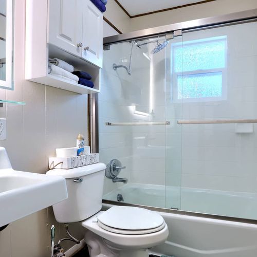 - spotless bathroom featuring a full size tub, glass doors, and rainfall showerhead
- stocked with plush towels, essentials, and extra shelving for a hassle free stay
- bright space with sleek finishes and everything you need to feel right at home