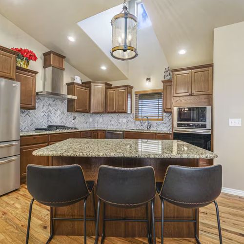 A modern kitchen with stainless steel appliances and a sleek granite countertop, perfect for preparing your favorite meals, just like at home.