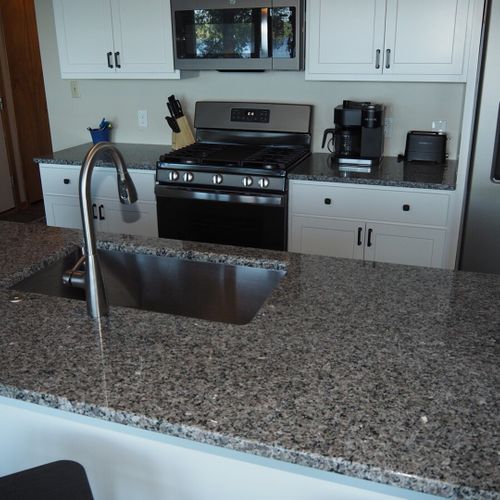 Kitchen:  newly remodeled and features a gas stove and stovetop, refrigerator, microwave oven, dishwasher, keurig coffee maker, toaster, island with sink, barstools, lots of counter space and cabinets, and a good supply of cooking & dining utensils.