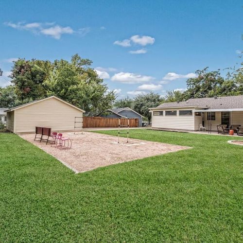 Fun, fenced backyard with ladder ball, fire pit, hammock and parking at the garage behind a locked gate.