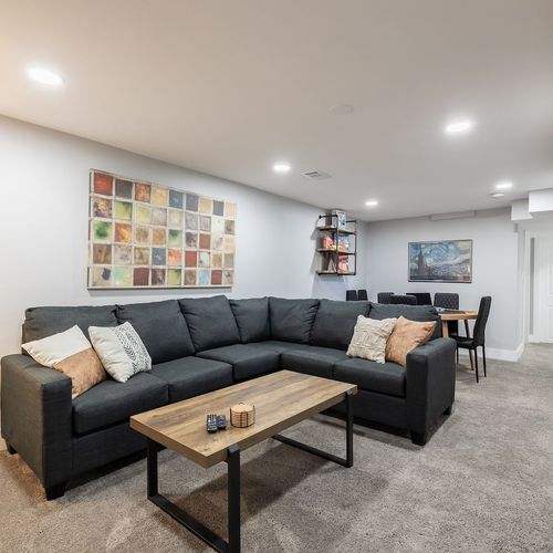 - stretch out on a comfy sectional perfect for family movie nights or casual hangs
- explore shelves stacked with board games for endless entertainment and bonding
- share meals or game night snacks around the sleek dining table in the back