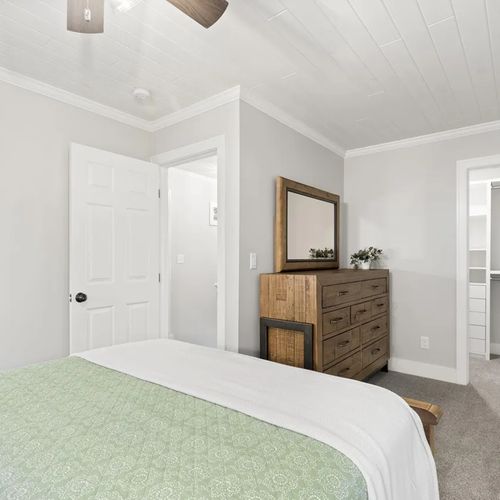 BEDROOM #4 (UPPER LEVEL):  Beautiful upper level bedroom with a queen-size bed, nightstands, lamps, ceiling fan, mirror, dresser, and closet