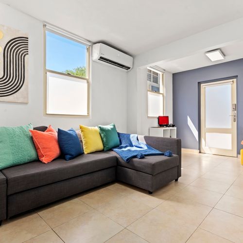 Relaxation awaits. This modern and cozy living room, with its colorful accents, is the ideal place to kick back and enjoy your stay.