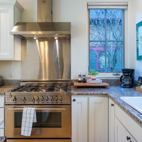 Cook comfortably in this well-appointed kitchen featuring a gas range, stainless steel hood, and granite countertops.