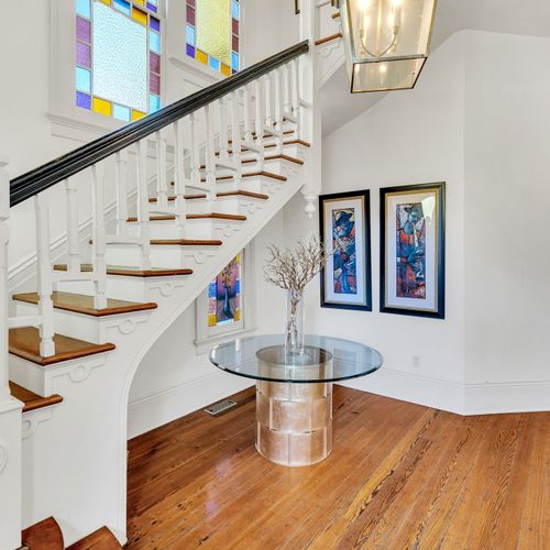 Bright stained glass accents a grand historic staircase.