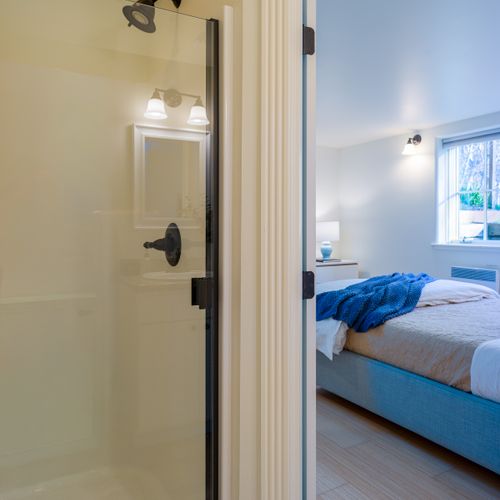 En-suite bathroom with a glass walk-in shower, offering comfort and convenience just steps from the bed.