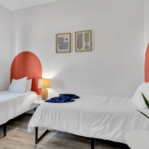 Twin bedroom w/ coral headboard, matching bedding, & a cheerful, personality-filled vibe.