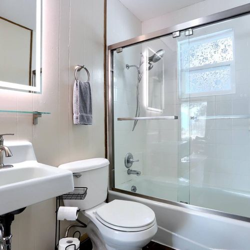 - refresh in a pristine white tub with sliding glass doors and rainfall showerhead
- soft towels, led mirror lighting, and clean lines create a spa like feel
- decor elements and floral frosted window bring in that forest cabin magic