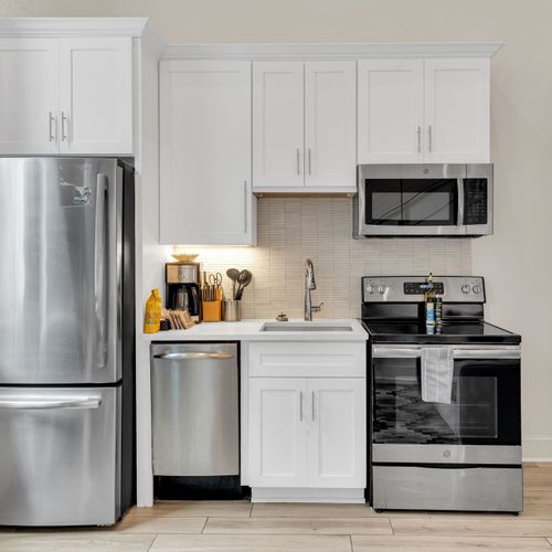 Modern kitchen w/ stainless steel appliances, ready for home-cooked meals.
