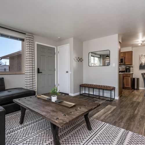 Bask in the natural light of the stylish lounge area, featuring a plush sectional, boho accents, and an industrial coffee table.