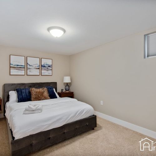 The lower level bedroom is fitted with a queen size bed, matching nightstands with accent lamps, and a closet for extra storage space.