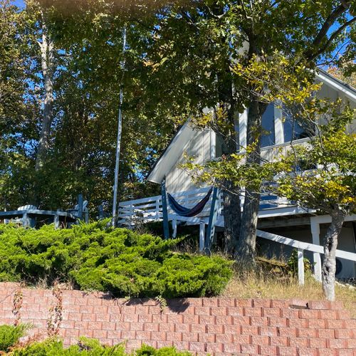 EXTERIOR:  West side of the cottage facing Lake Michigan, highlighting the beautiful wrap-around deck