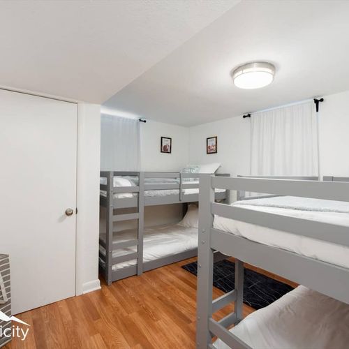 - sleepover ready room with two sets of twin bunk beds for fun group stays
- clean white linens, bright lighting, and neutral walls keep the space fresh
- great option for kids or groups who want to sleep close and stay cozy