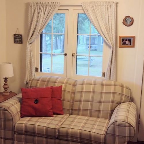 Living room:  the cabin has cute living room with a loveseat, dining table, comfy chair, and streaming television.
