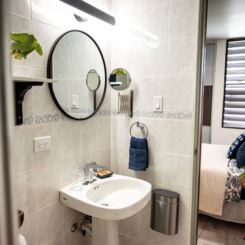 Freshen up with ease at our practical bathroom vanity, complete with a round mirror, extra magnifying mirror, and a convenient towel ring. Everything you need is right at hand.