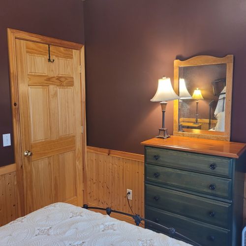 Bedroom #1 (main floor):  features a queen-size bed, dresser, mirror, nightstands, and lamps.