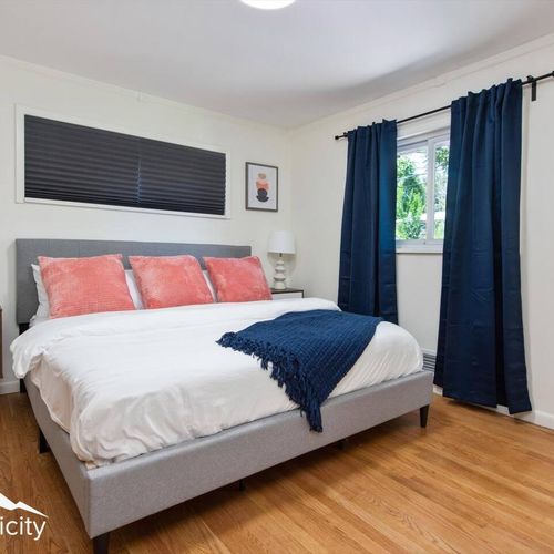 - serene king bedroom with navy blackout curtains and coral accent pillows
- cozy bedding and sleek gray frame set the tone for restful nights
- hardwood floors and natural light complete this calming retreat