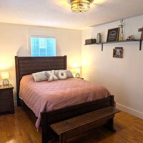 BEDROOM #1 (MAIN FLOOR):  Gorgeous main floor bedroom with a queen-size bed, nightstands, lamps, ceiling fan, dresser, mirror, and closet.