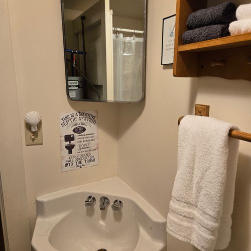 Bathroom:  there is a full bathroom with a shower, sink, vanity, mirror, and toilet.