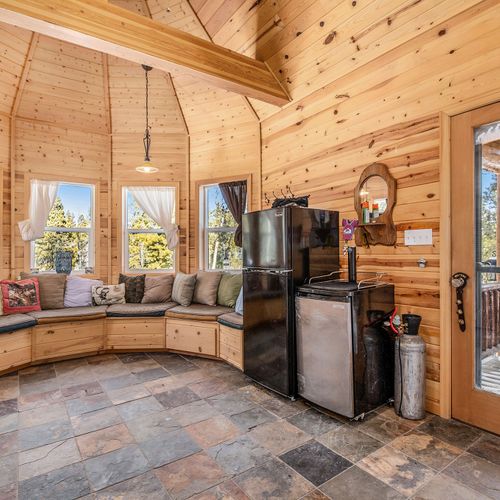 - unique turret style nook with wraparound bench seating and towering windows