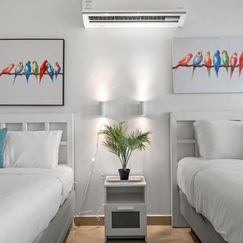 Charming studio with two comfortable beds and a private balcony for mesmerizing ocean views. Enjoy vibrant decor and comfort.