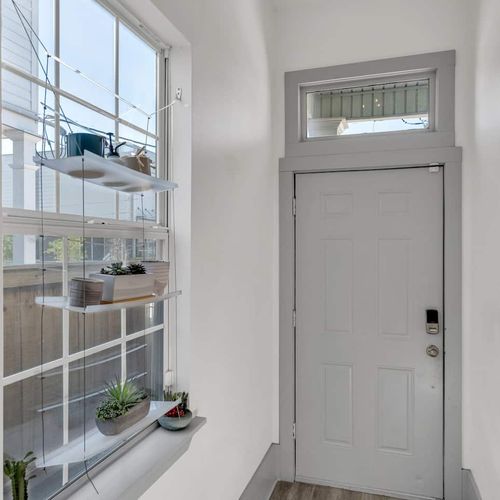Soft gray bedroom w/ natural light & a calm, welcoming atmosphere.