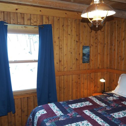 Bedroom #2 (main floor):  features a queen-size bed, nightstand with a lamp, a dresser, and a closet.