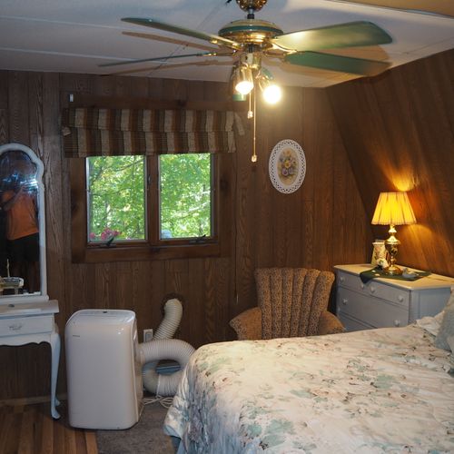 Bedroom:  includes a queen-size bed, dressers, night lamps, ceiling fan, closet, and room a/c unit.